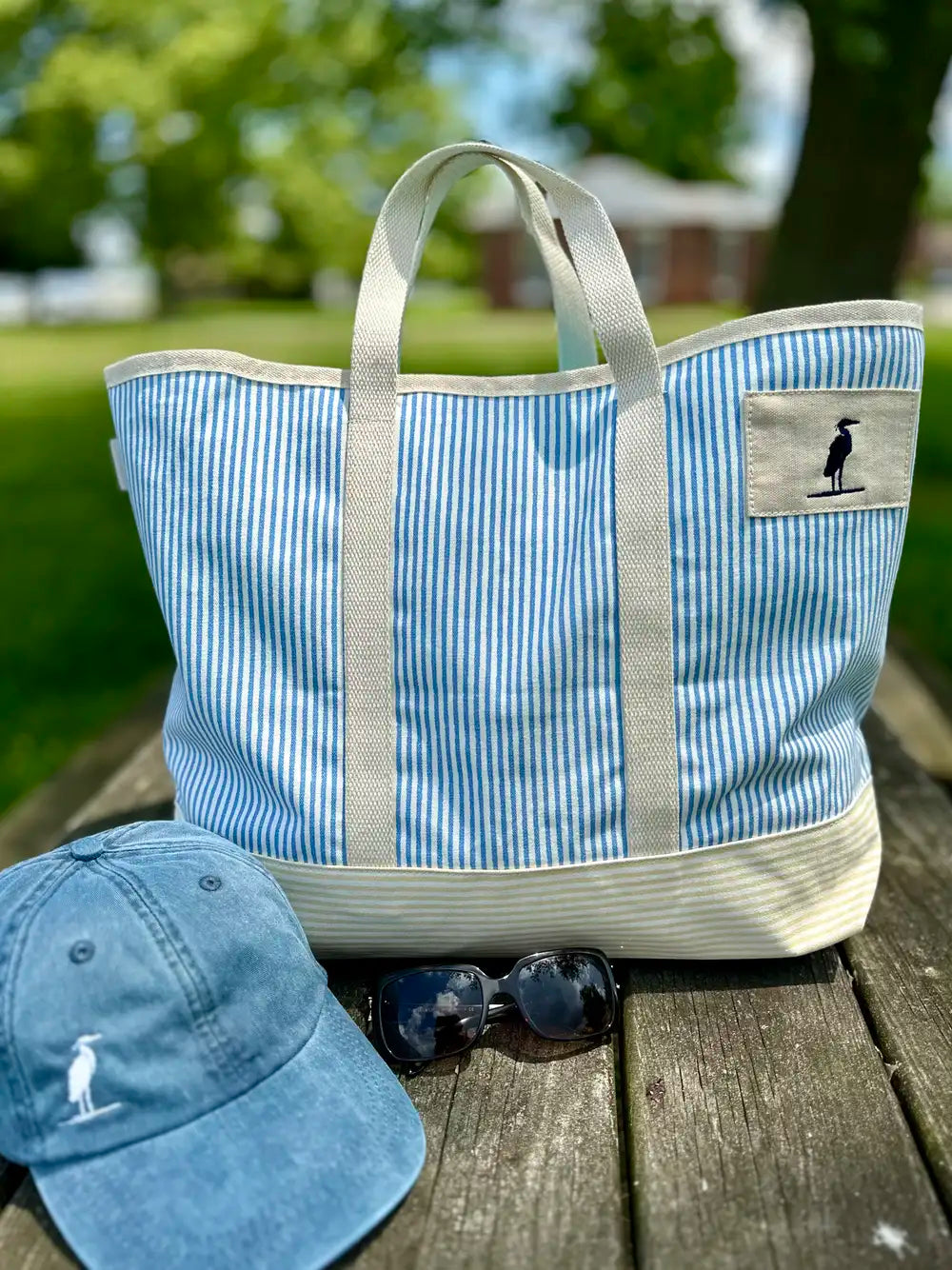 Tote Bag with heron icon embossed on the front. The bag is pinstriped with a pretty blue on white. The bag is made of canvas with sturdy straps. Eastern Shore Style. Boat tote bag, Beach tote bag, everyday bag.