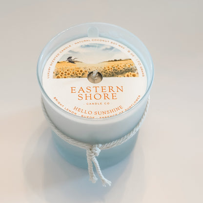Eastern Shore Candle - Hello Sunshine scent in 6oz container against a white background.  Inside is a dust cover to protect the candle. 